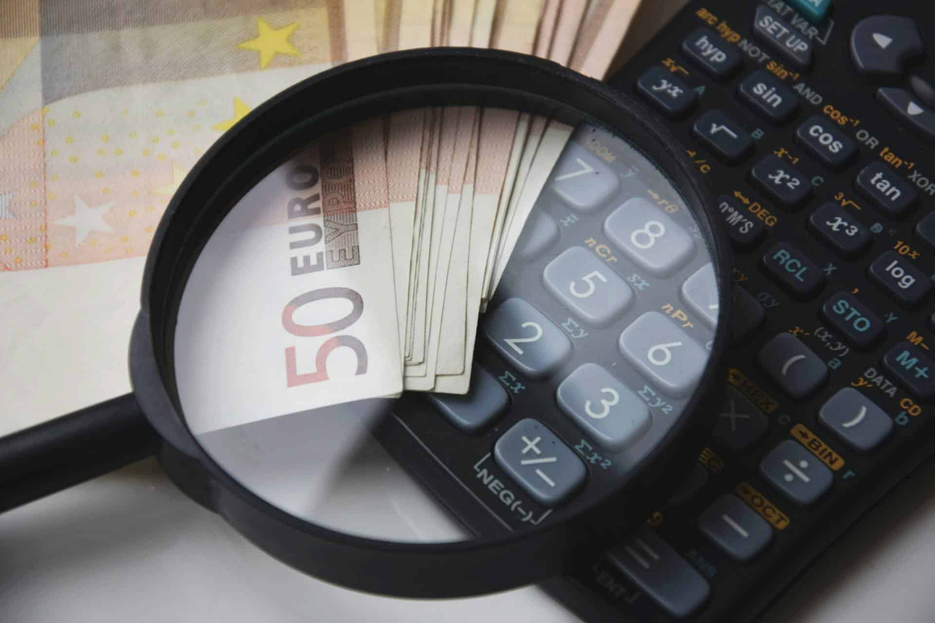 Une loupe, des billets de 50€, une calculatrice illustre les prestations financières à Reims.