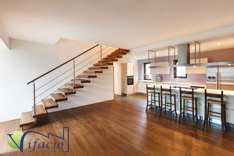 Cuisine ouverte moderne, parquet, escalier flottant, bar avec fauteuils hauts pour confort et services à domicile.