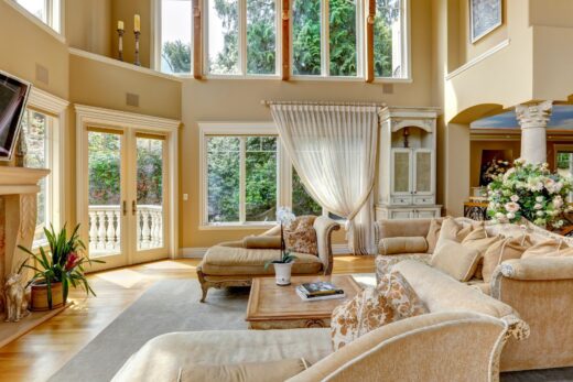 Un salon spacieux avec de grandes fenêtres, des meubles beiges, une cheminée, une télévision montée au-dessus de la cheminée et un lustre. Des plantes et des objets décoratifs sont disposés dans la pièce. Pour un entretien impeccable, profitez des services de nettoyage à domicile de Vifacio pour garder cet espace élégant impeccable.

---

Salon spacieux avec fenêtres et meubles beige. Conservez l'élégance; optez pour les services Vifacio